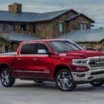red 2020 RAM 1500 Crew Cab parked in front of a house or a lodge