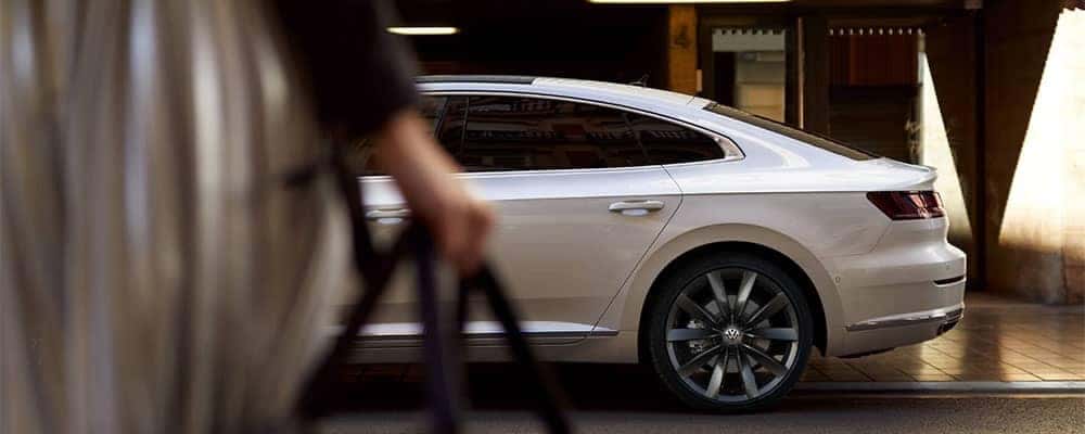 Woman walking to a Volkswagen Arteon