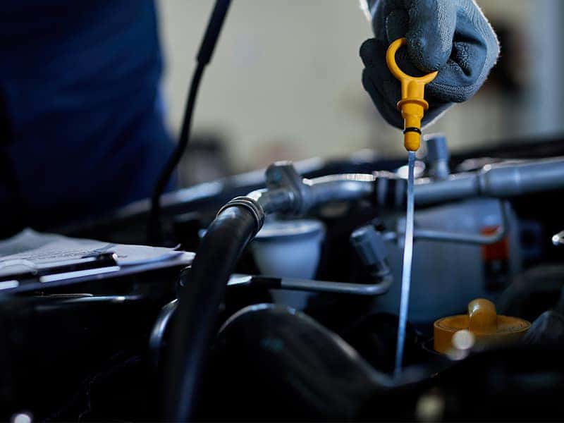 Checking engine oil level with dipstick during routine car maintenance