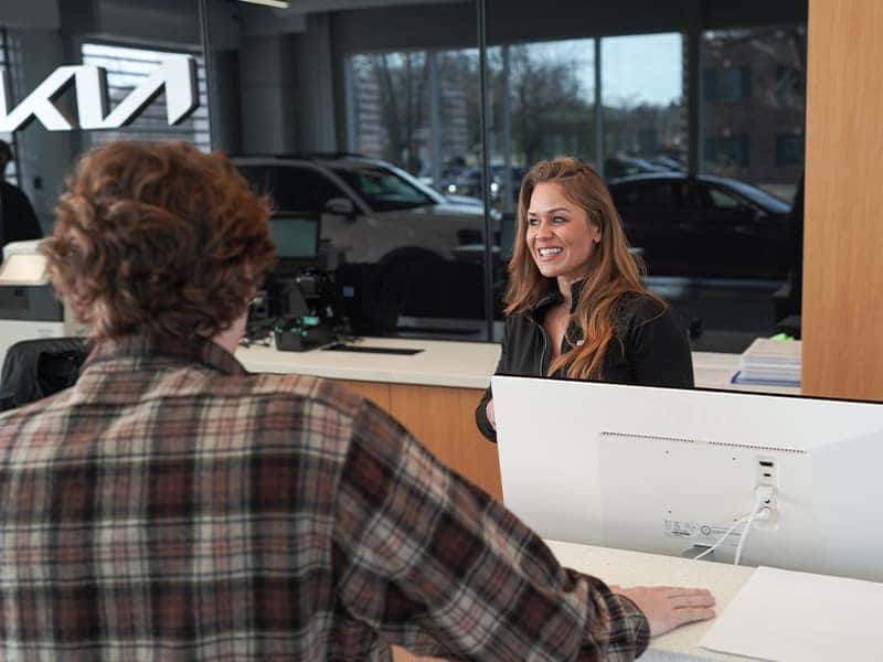 Service advisor assisting a customer during a vehicle service visit at the dealership service desk