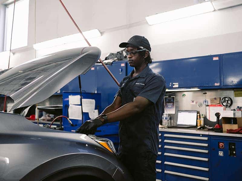 Technician performing a routine oil change and vehicle inspection at a Walser service center