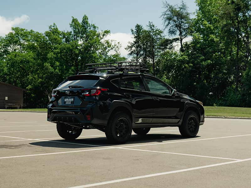 2026 Subaru Crosstrek Wilderness towing a small boat on a gravel road