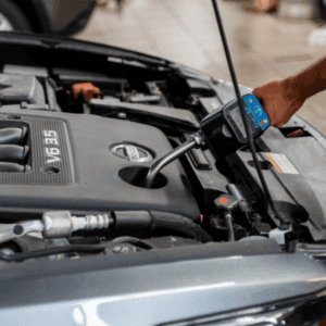 Close up of someone topping off fluids under the hood of a car