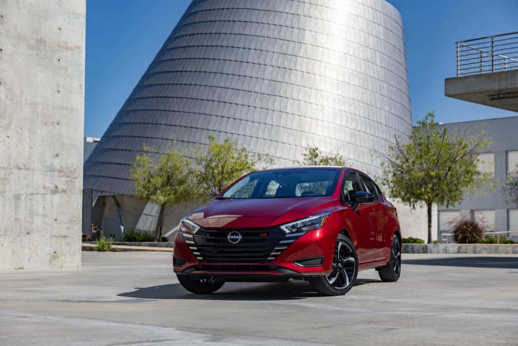 Red 2024 Nissan Versa parked in front of a building