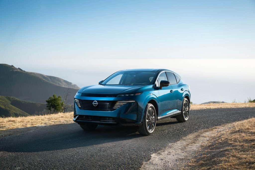 Blue 2025 Nissan Murano driving down a quiet road