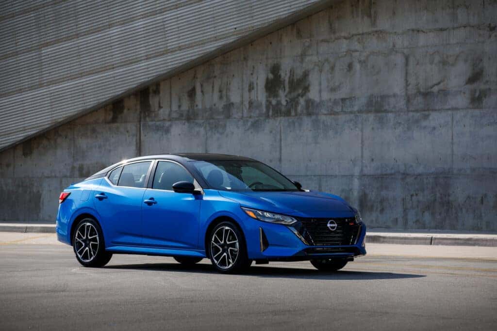 Blue 2025 Nissan Sentra parked in front of a concrete structure