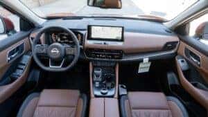 Front seat steering wheel and infotainment center of a 2024 Nissan Rogue