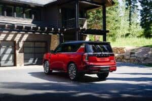 Red 2025 Nissan Armada Platinum Reserve Parked in front of a garage
