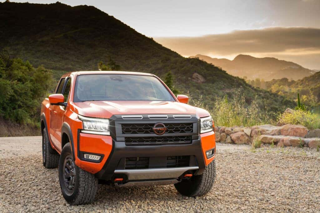 Orange 2025 Nissan Frontier parked in front of mountains
