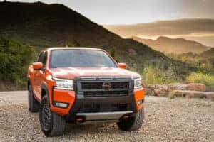 Orange 2025 Nissan Frontier parked in front of mountains